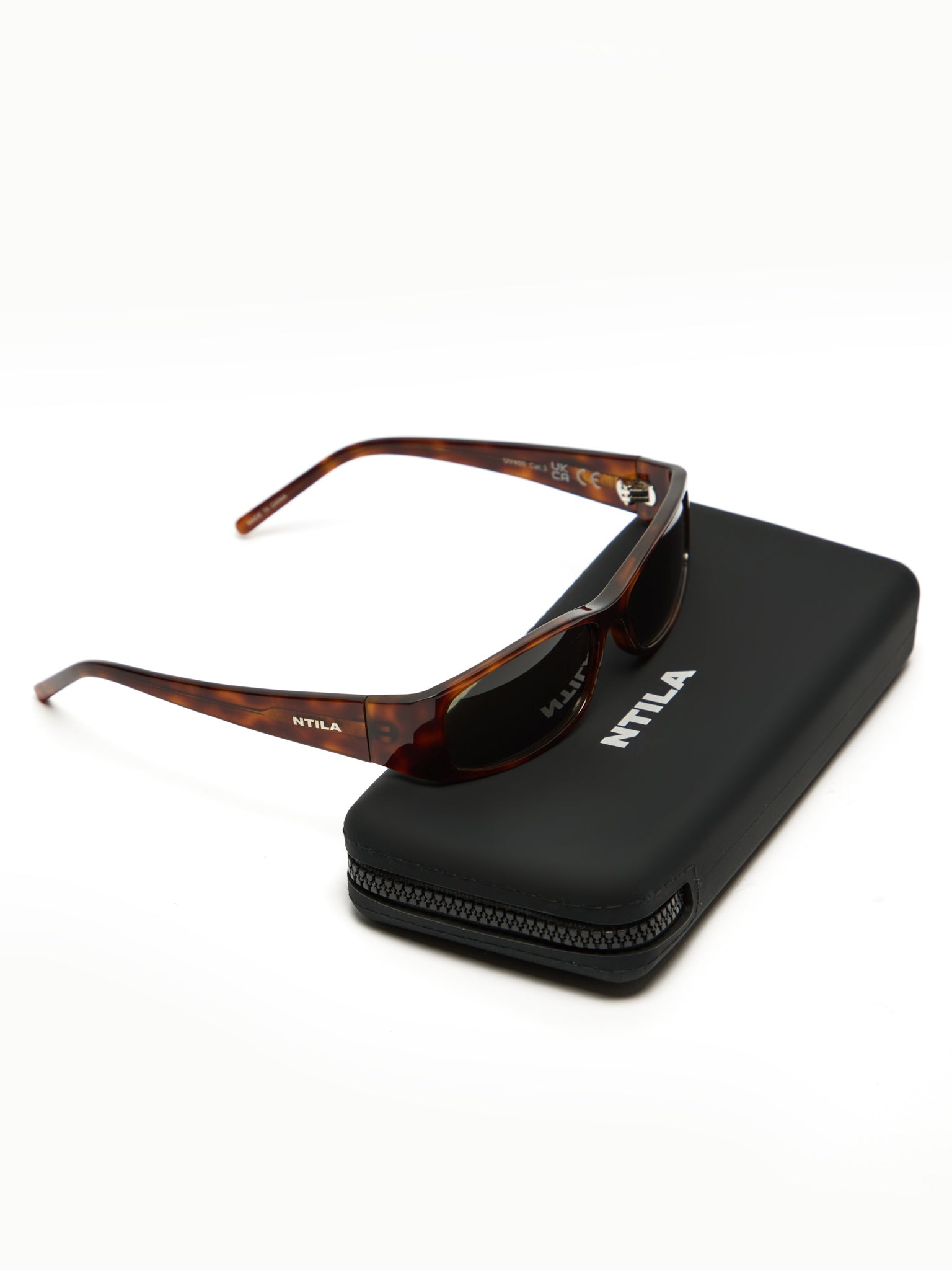 NTILA black tort Sunglasses with tortoiseshell frame on a black case, featuring the NTLA brand.