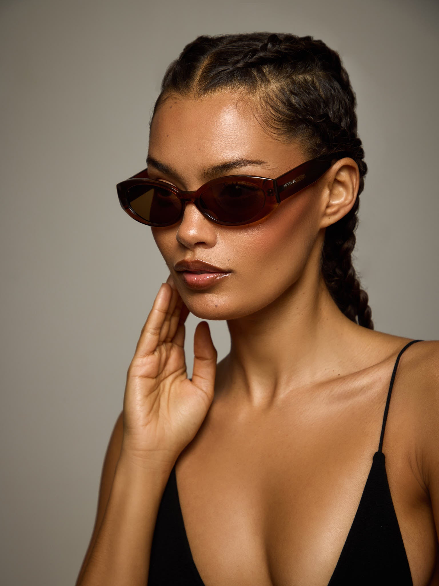 Woman wearing Cleo brown oval sunglasses with a neutral background